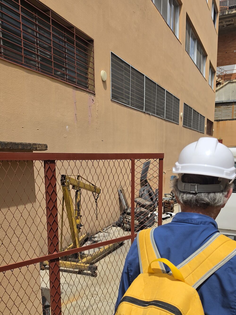 Inspector de Corporación 3JC frente a la fachada de un edificio en Caracas con una grieta resanada en la pared