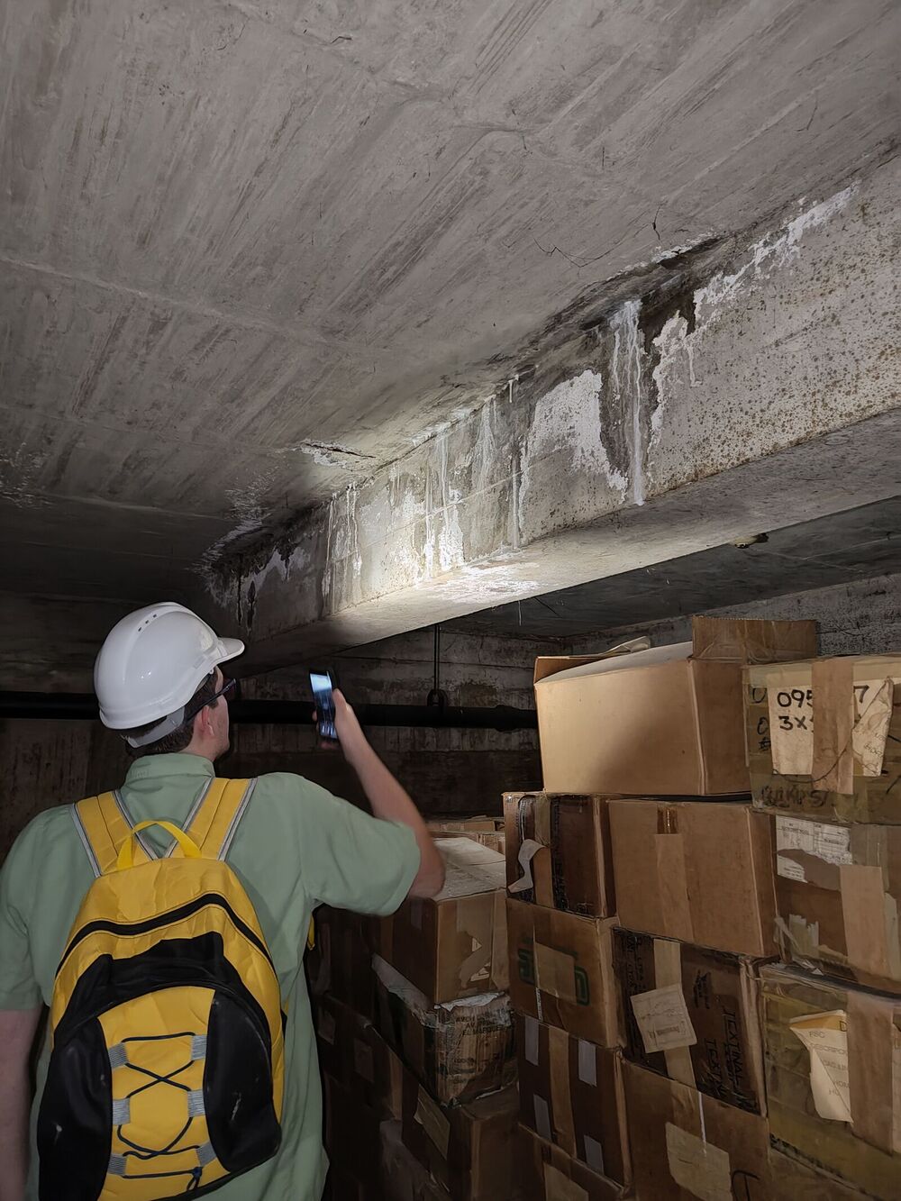 Técnico de Corporación 3JC documentando el deterioro del concreto en una viga y la losa de un depósito en Caracas